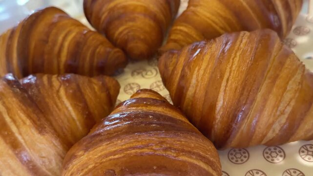 Freshly baked croissants displayed in a bakery window