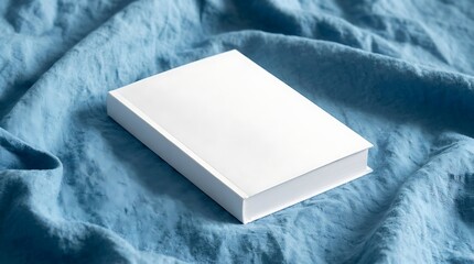 Fototapeta premium Empty white book cover mockup on blue bedding