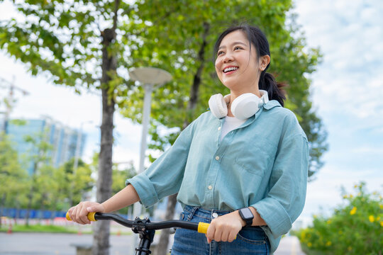 Asian woman cycling in cities for morning commutes, adventure, or outdoor travel.