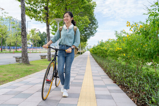 Asian woman cycling on a natural road.