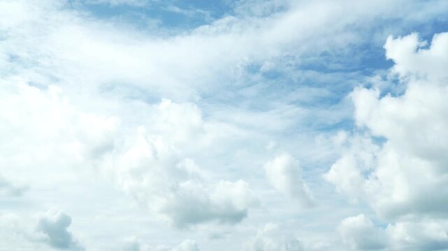 Cinematic timelapse of large, fluffy white cumulus clouds swiftly drifting across a vivid azure sky&nbsp;&mdash;&nbsp;the clouds constantly transform and change shape while flowing with the wind, creating sky. 