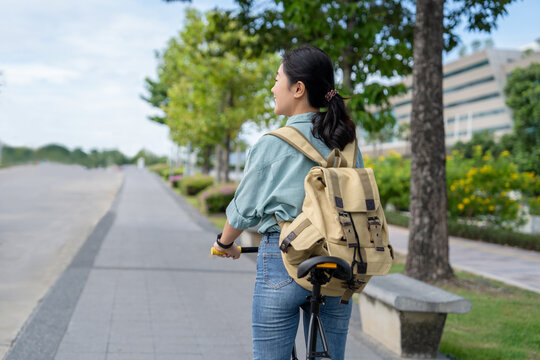 Asian woman rides her bike to work on a nice day