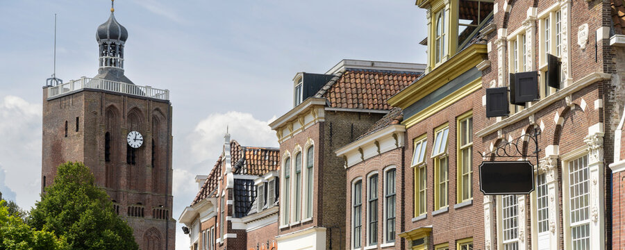 Historic church tower and town square in Workum, Friesland, The Netherlands with cafes and people