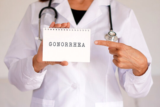 Medical concepts. Female doctor pointing to the word "gonorrhea" in her medical notebook.
