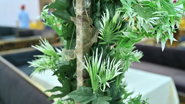 Close Up of Artificial Green Foliage Decoration with Blurred Event Background