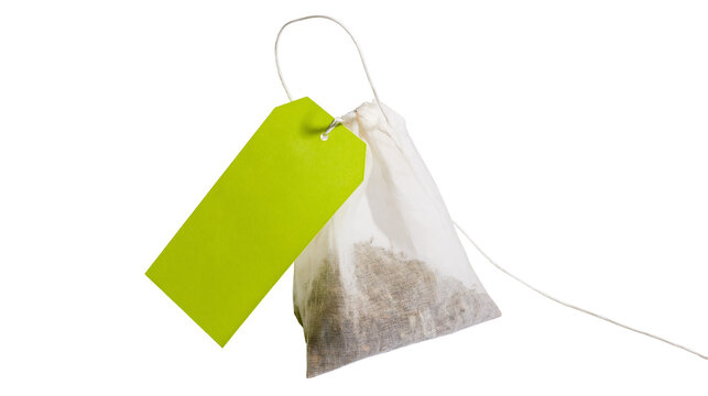 Tea bag with green tag and dried tea leaves