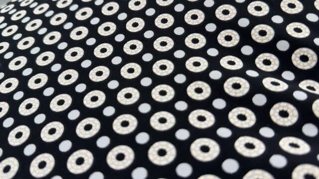 Black fabric with white geometric circle pattern creating stylish abstract textile background with repeating decorative design and modern seamless texture