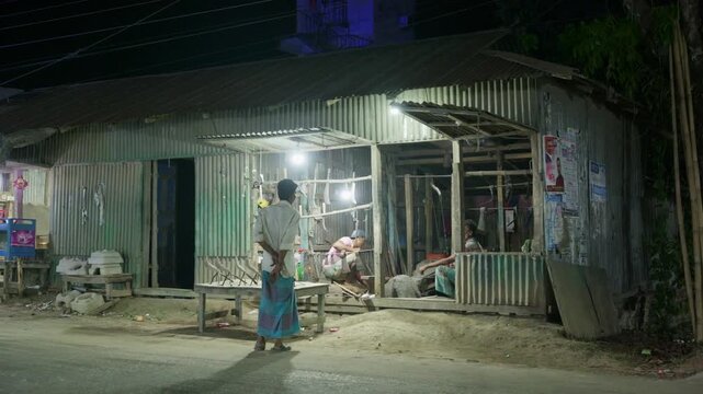 Traditional South Asian Bangladeshi blacksmith reshaping glowing red-hot metal sickles with hammer on anvil