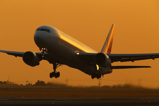A Boeing 767 airliner taking off at sunset in Aso Kumamoto Airport, Japan.