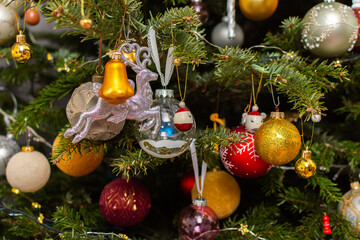 Obraz premium A Christmas tree stands with many colorful ornaments hanging from its branches. Each ornament shows different shapes and colors, celebrating the festive season and bringing joy to the home