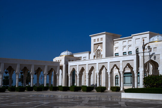 Horizontal medium shot of the intricate white marble facade and columned porticos of Qasr Al Watan presidential palace, Abu Dhabi.