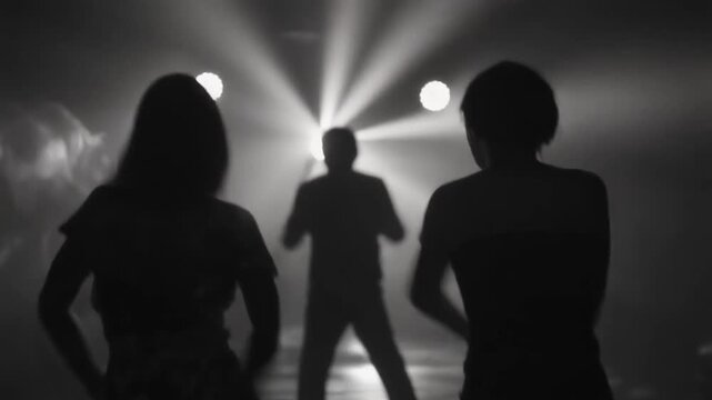 暗いクラブでリズミカルなストロボライトに照らされて踊る人々のシルエット