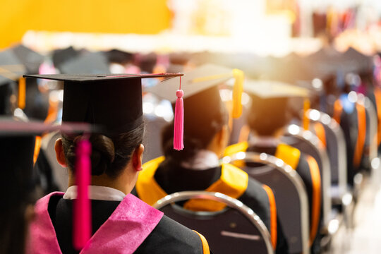 University graduates in vibrant academic gowns and mortarboard caps gather during a glowing cinematic commencement ceremony celebrating educational achievement.
