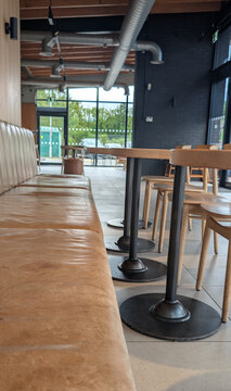 Modern airy cafe interior empty depicting leather bench seat, table and chairs