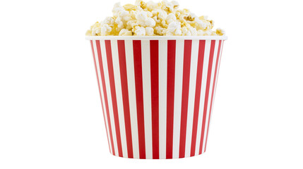 Red and white striped bucket overflowing with popcorn © Solene