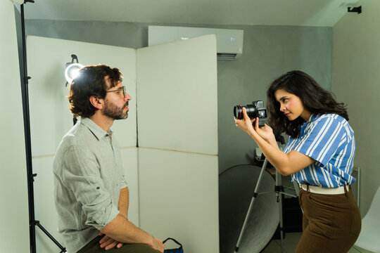 Actor doing headshot recording in a studio, female photographer working with talent for an audition