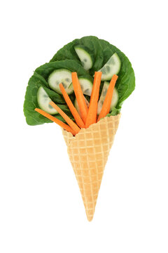Surreal lettuce leaf cucumber carrot ice cream cornet fun whimsical diet concept design on white background. Healthy summer green organic vegetable food art.