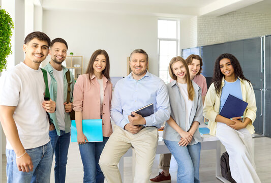 Teacher students group in classroom mastering learning. Smiling educator with diverse young adults after lesson. Modern college vibe supports focused education. Strong study success concept now.