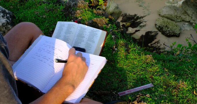 Man Doing a Bible Study Outdoors on Scenic Cliff in Bali