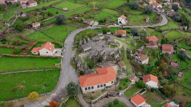 Aerial view of the historic stone Granaries of Soajo surrounded by lush green fields and traditional houses in Soajo, Viana do Castelo, Portugal.