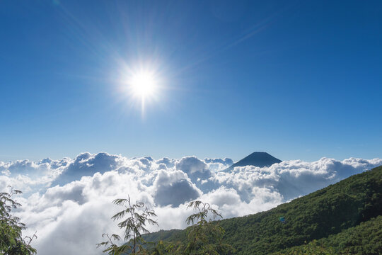 Beautiful sea of clouds under a bright shining sun and blue sky at Mount Sumbing, Indonesia