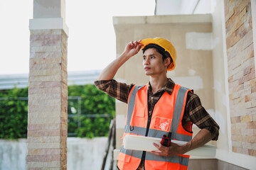 Foreman with safety vest surveying new house construction project © Crystal
