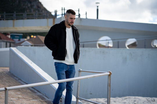 man with a thoughtful look standing in the street casually