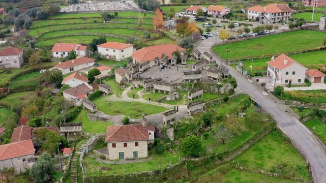 Aerial view of the historic stone granaries of Soajo surrounded by rural houses and green fields in Soajo, Viana do Castelo, Portugal.