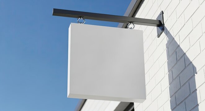Blank white square hanging sign on brick wall.
