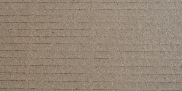 Top view close up of brown craft cardboard texture with parallel horizontal lines and copy space