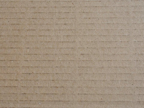 Top view close up of brown craft cardboard texture with parallel horizontal lines and copy space