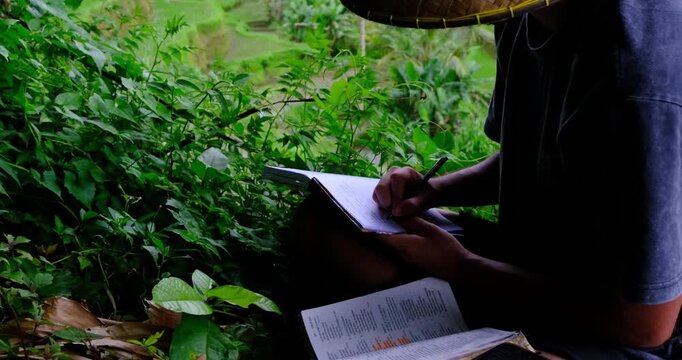 Time lapse of Man Reading the Bible and Journaling in Lush Rice Fields of Bali, Indonesia