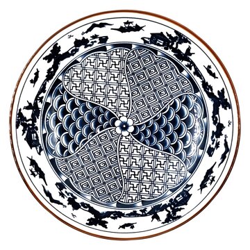 Top view of a traditional East Asian blue and white ceramic plate, showcasing intricate geometric patterns, repeating fish scale motifs, and an elegant hand-painted landscape border.