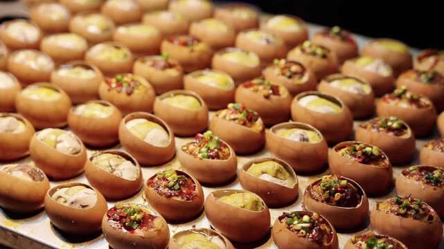 Various baked stuffed egg shells with different toppings, neatly arranged on a baking tray, ready for serving.