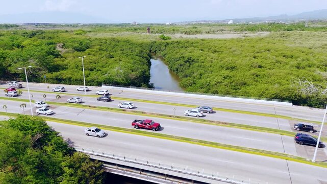 Aerial view of the highway bridge crossing the Estero El Salado protected area with lush mangrove vegetation and traffic in Puerto Vallarta, Jalisco, Mexico.