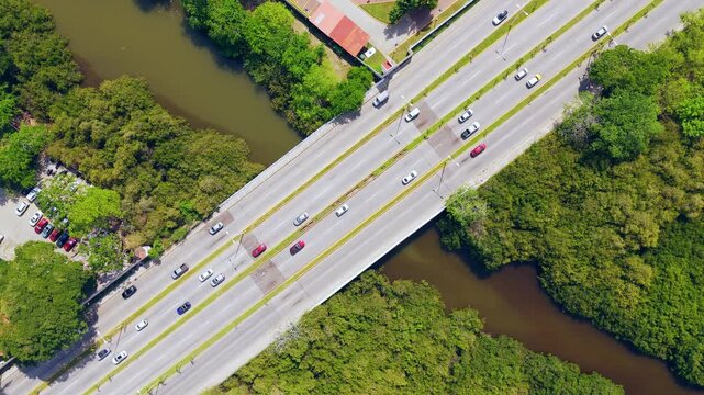 Aerial view of the bridge crossing the Area Natural Protegida Estero El Salado with cars driving on the highway surrounded by lush mangrove forests in Puerto Vallarta, Jalisco, Mexico.