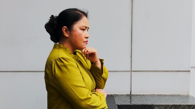 Serious Asian senior woman thinking and sighing with bad feeling