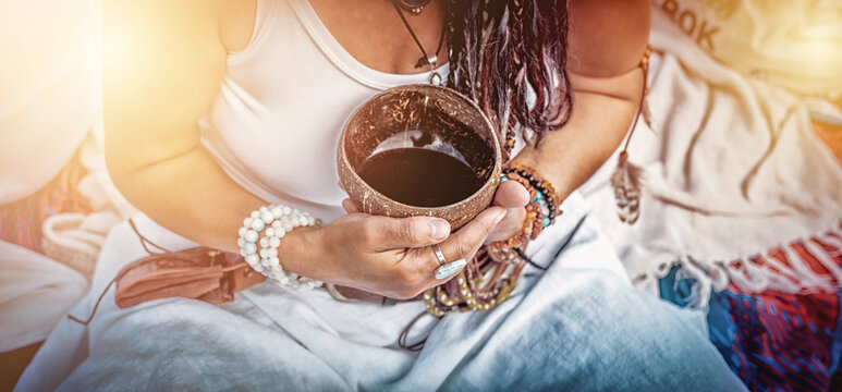 Woman holds a bowl of cocoa during a sacred cocoa ritual.