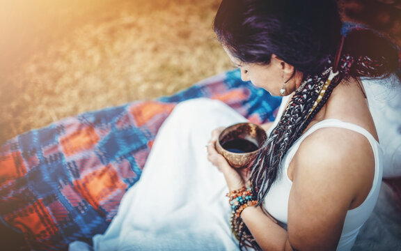 Woman holds a bowl of cocoa during a sacred cocoa ritual.