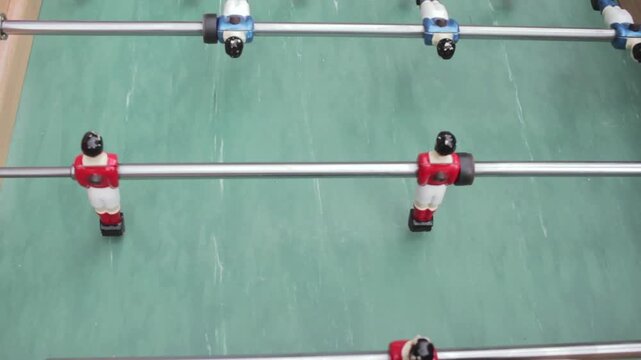Foosball table game with red and blue players on green field