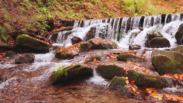 Large boulders overgrown with moss at waterfall