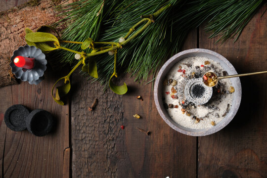Frankincense and dried herbs burning on glowing charcoal - placing incense with a spoon, copy space