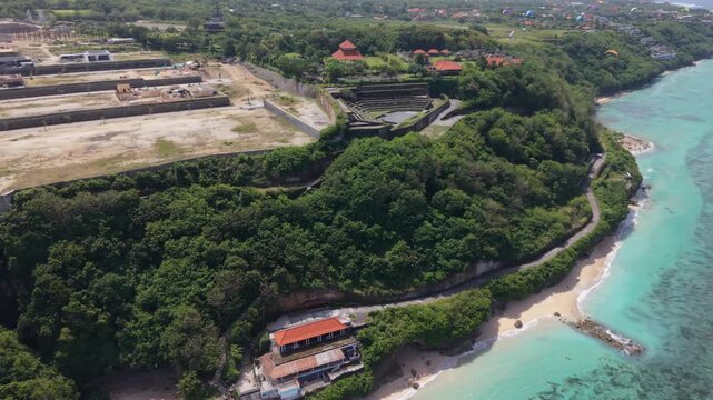 Aerial view of a cliffside stone amphitheater structure near Gunung Payung beach in Bali
