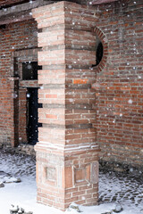 Obraz premium brick column of old building during snowfall