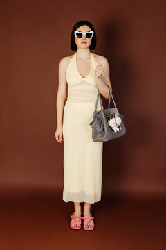 Woman in cream dress and heart sunglasses