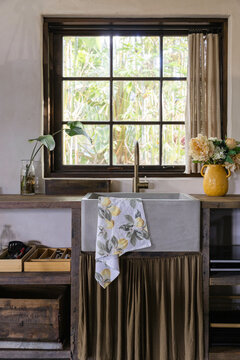 A rustic kitchen with concrete farmhouse sink and open shelving