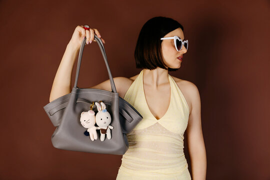 Woman holding handbag with rabbit charms