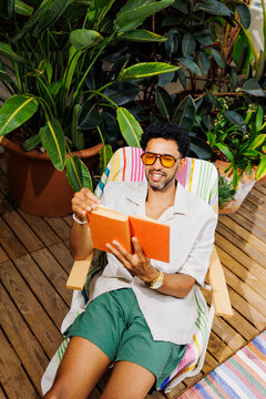 Person relaxing on terrace enjoying book on sunny day