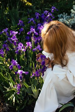 Anonymous woman with irises in garden
