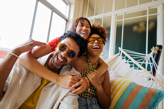 Diverse friends enjoying laughing and hugging together indoors